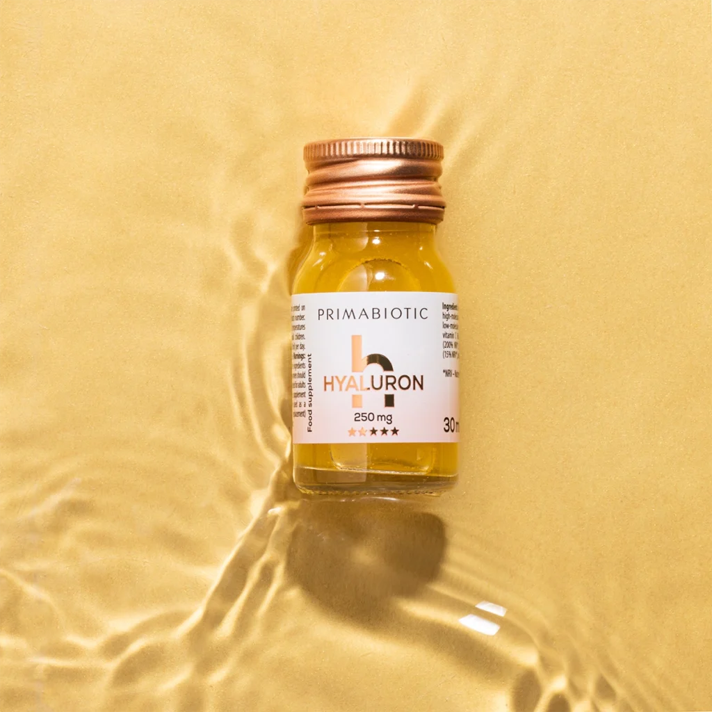 bottiglietta di Primabiotic Hyaluron 250 mg su sfondo dorato, integratore con acido ialuronico per idratazione e luminosità della pelle