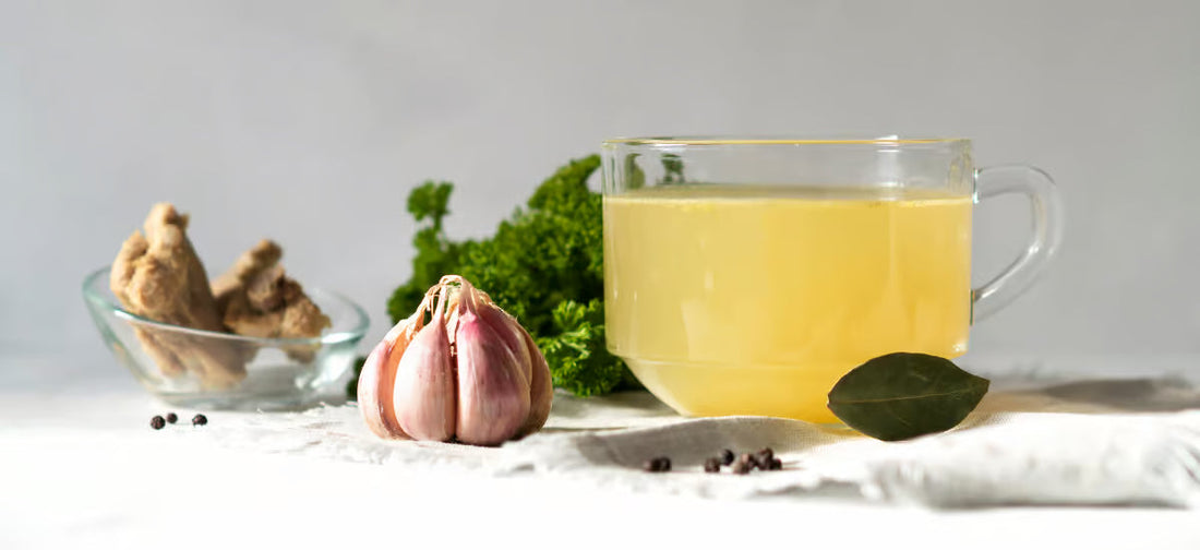 Il brodo di collagene in un bicchiere e dietro di esso le spezie