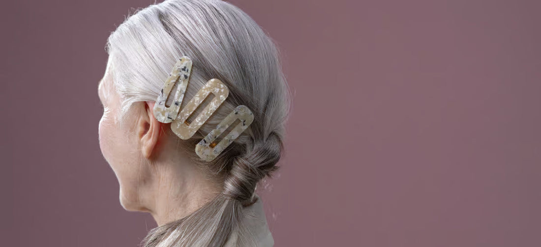 Donna di spalle con capelli grigi raccolti con fermagli