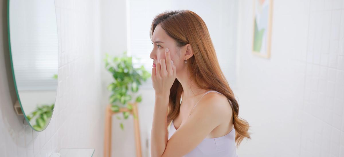 Una donna che si guarda allo specchio osservando le sue rughe