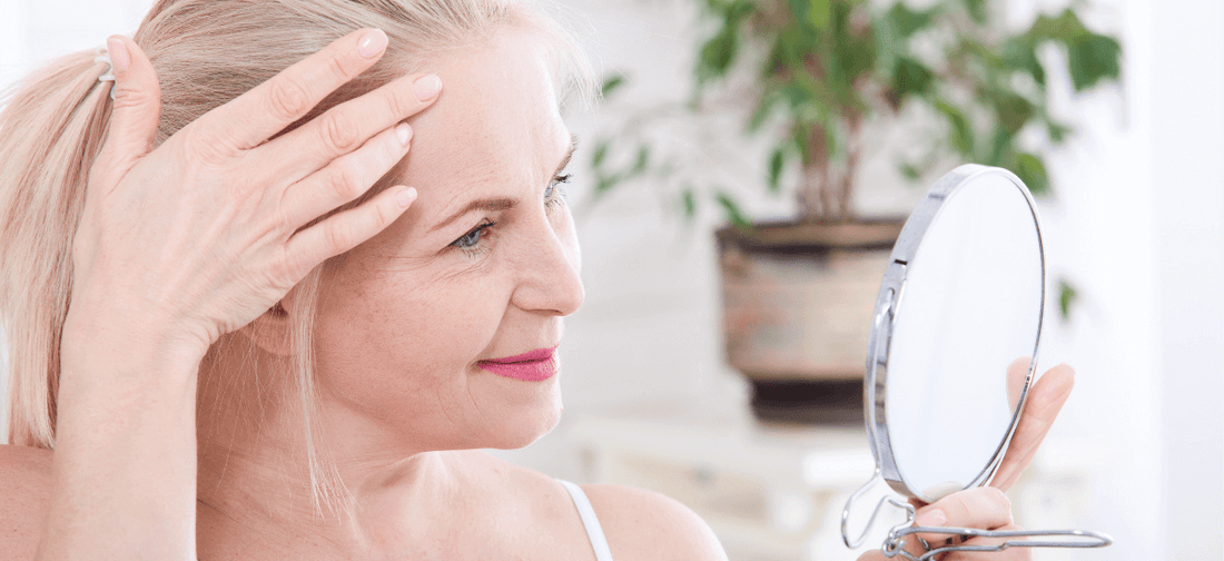 Una donna sorridente che si guarda allo specchio.