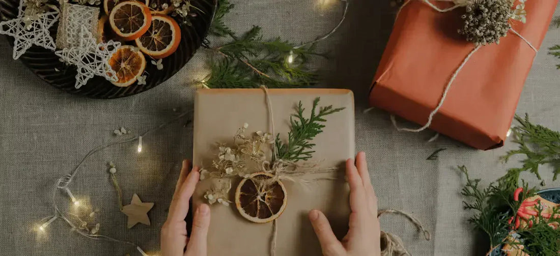 Mani che avvolgono un regalo decorato in stile naturale, perfetto per Idee regalo Natale