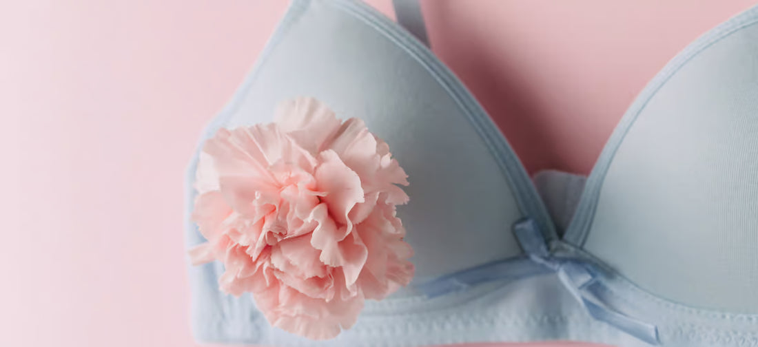 Reggiseno blu con fiore su sfondo rosa.