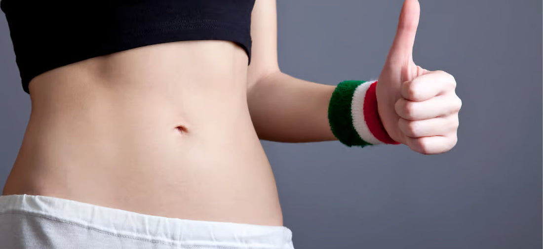 Donna con addome tonico, con il pollice alzato