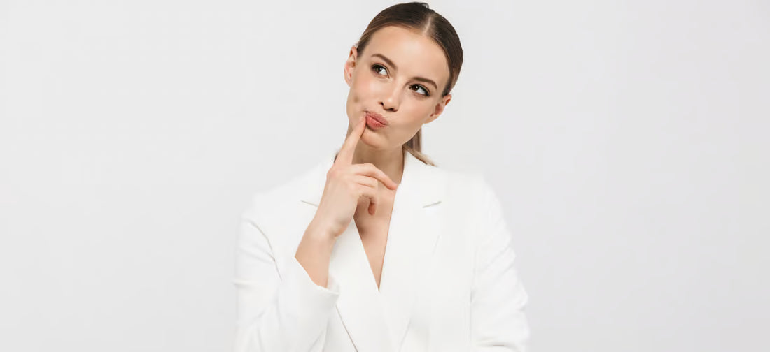 Una donna in tailleur bianco che riflette sulla scelta di un collega.