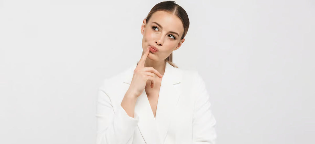 Una donna in tailleur bianco che riflette sulla scelta di un collega.