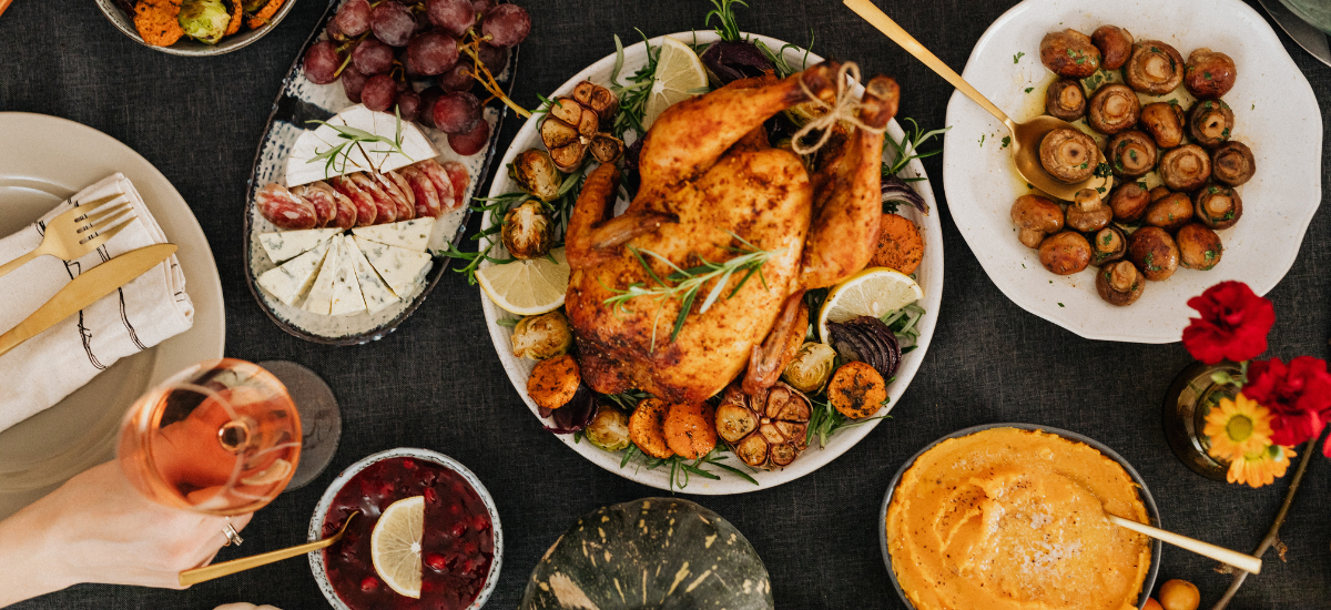 Pollo arrosto e altri piatti disposti su un tavolo nero