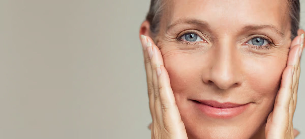 Donna anziana si tiene il viso con entrambe le mani