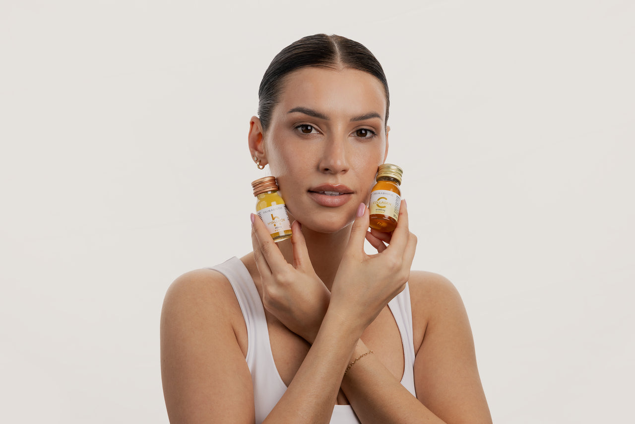 flaconcini di collagene Primabiotic tenuti da donna giovane con capelli raccolti