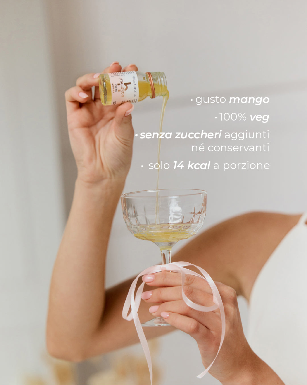 flaconcino Primabiotic Hyaluron versato in un bicchiere con scritte gusto mango 100% veg senza zuccheri aggiunti solo 14 kcal