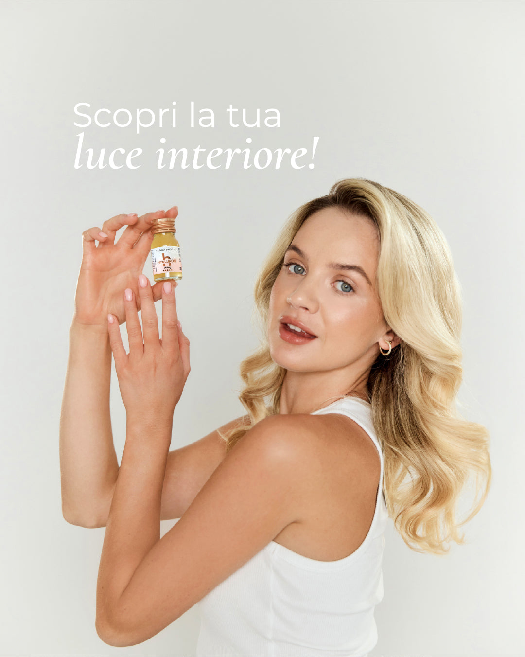 donna bionda con flaconcino Primabiotic davanti alla scritta Scopri la tua luce interiore